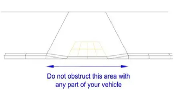 Dropped kerb with blue line showing the area that must not be obstructed by any part of a vehicle.