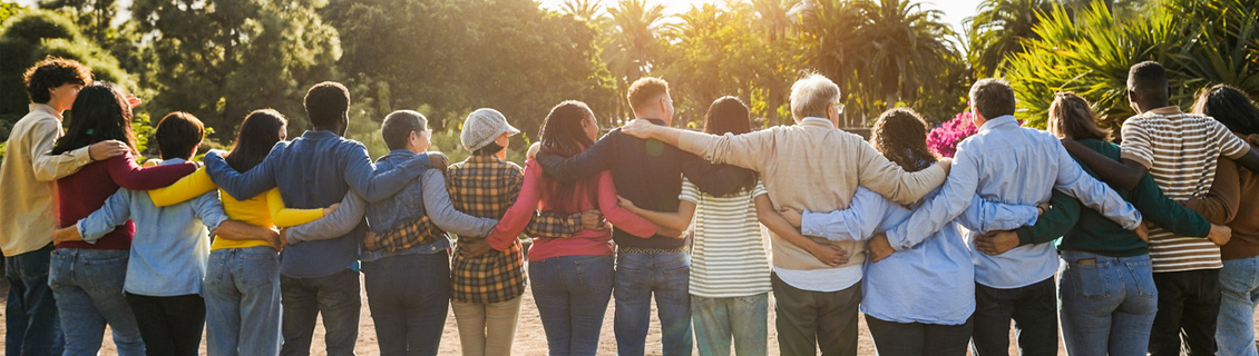 Diverse group of people standing in a line with hands over each other shoulders as a sign of community and unity