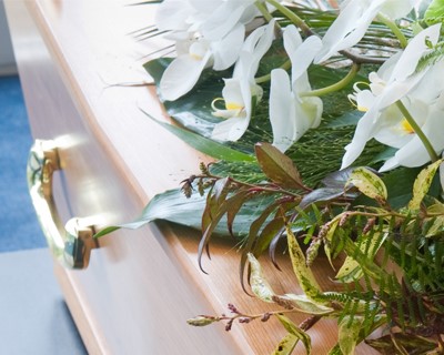 A coffin with a flower arrangement in a morgue